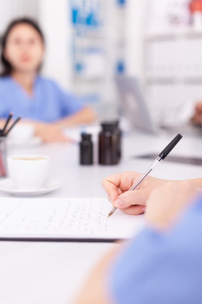 Nurse writing on clipboard